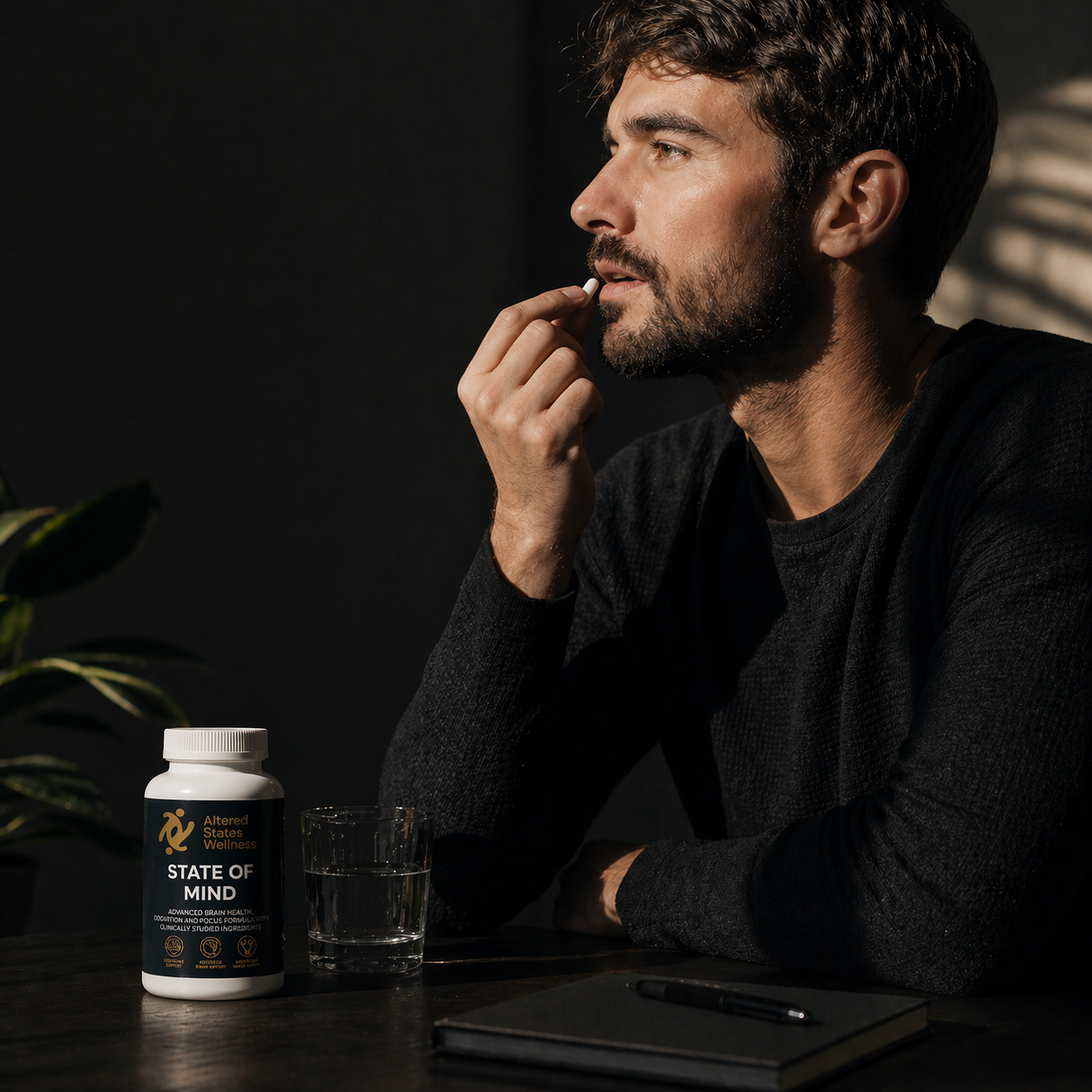 Man taking a supplement with a 'State of Mind' container on a table.